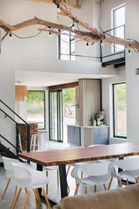 une salle à manger avec une table en bois et des chaises blanches dans l'établissement Pilanesberg Private Lodge, à Pilanesberg