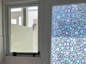 una ventana con un vidrio azul y blanco estampado en Alamos Tandil en Tandil