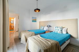 1 Schlafzimmer mit 2 Betten und blauer Bettwäsche in der Unterkunft Holidays Octopussy in Montinhos da Luz