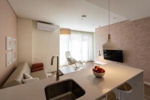 a kitchen with a sink and a bowl of fruit on a counter at APARTAMENTOS TURISTICOS QUINTA LA PLAZA in Quintanadueñas