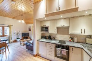 a kitchen with white cabinets and a living room at Wildcat Lodge in Cray