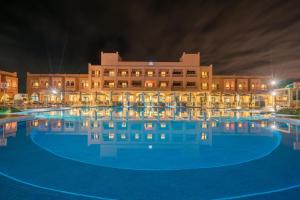 a large pool in front of a building at night at Pickalbatros Aqua Fun Club All Inclusive in Marrakech