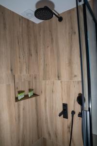 a bathroom with a shower with a wooden wall at Central Suites Aegina 2 in Aegina Town