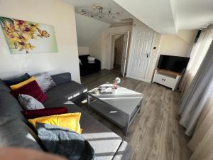 a living room with a couch and a tv at Edge of Glastonbury and Street Town Centre, 2BD Apt with Parking in Street