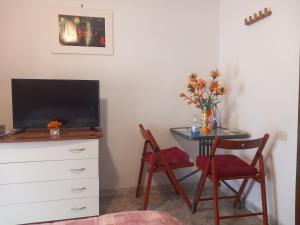 a room with a desk with a tv and a table with chairs at Al Chiaro Di Luna in Taranto