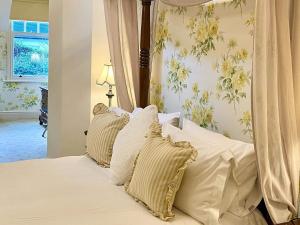 Schlafzimmer mit einem Bett mit weißer Bettwäsche und Kissen in der Unterkunft Storrs Gate House in Bowness-on-Windermere