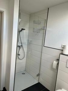 La salle de bains est pourvue d'une douche avec une porte en verre. dans l'établissement Mühlbachs 2, à Kaufbeuren