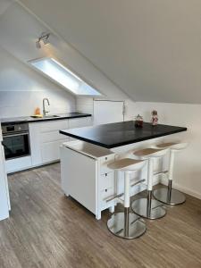 a kitchen with white cabinets and a black counter top at Mühlbachs 2 in Kaufbeuren