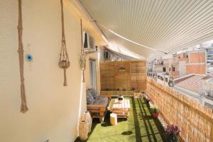 a balcony with a couch and a table on a building at Cozy Apartment in the heart of Athens! in Athens