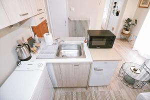 a small kitchen with a sink and a microwave at Cozy Apartment in the heart of Athens! in Athens