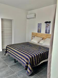 ein Schlafzimmer mit einem Bett mit gestreifter Decke in der Unterkunft tytoun evasion in Borgo