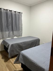 2 Betten nebeneinander in einem Zimmer in der Unterkunft Casa Confortável e Aconchegante in Brotas