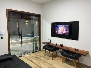 a living room with a television on a wall at Casa Confortável e Aconchegante in Brotas
