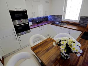 a kitchen with a table with a vase of flowers on it at Private Room in Modern Apartment in Aberdeen