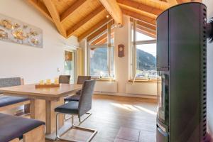 a kitchen and dining room with a table and a refrigerator at Landhaus Kendler in Saalbach Hinterglemm