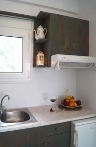 eine Küche mit einem Waschbecken und einer Schale Obst in der Unterkunft Pygolampida Studios in Mytilini