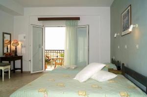 a bedroom with a bed with pillows and a balcony at Pygolampida Studios in Mytilene +6 photos