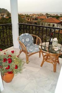 a balcony with a chair and a table and flowers at Pygolampida Studios in Mytilini