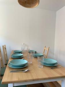 a wooden table with plates and glasses on it at Apartamento PC in Torrelavega