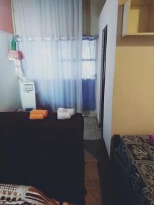Habitación con 2 camas y ventana con cortina en Departamentos Termas en Termas de Río Hondo