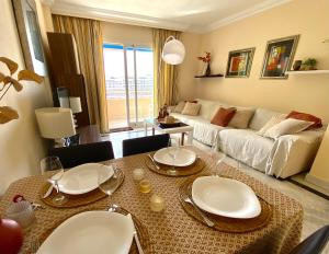 uma sala de estar com uma mesa e um sofá em Beach apartment in Puerto Banus - Free parking - Wifi - swimming pool em Marbella