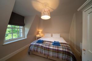 a bedroom with a bed with blue towels on it at Gatehouse, Bridge of Balgie, Glenlyon 