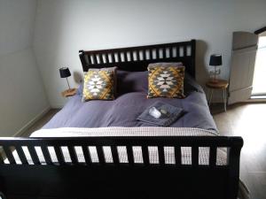 a black bed with pillows and a clock on it at Langs De Maas in Boxmeer