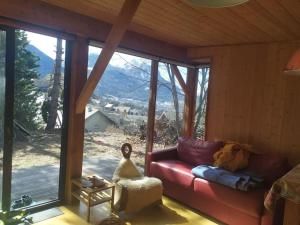 a living room with a red couch in front of a window at cabane de charme in Briançon