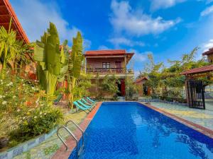 a villa with a swimming pool in front of a house at Cosiana Homestay in Ninh Binh