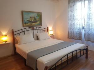 a bedroom with a large white bed with two lamps at Apartments Helena Pomer in Pomer