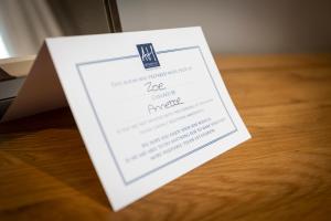 a white card sitting on top of a wooden table at Aberdunant Hall in Porthmadog