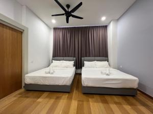 2 Betten in einem Zimmer mit Deckenventilator in der Unterkunft Plaza Arkadia Desa Parkcity by KLhomesweet in Kuala Lumpur
