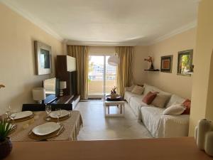 uma sala de estar com um sofá e uma mesa em Beach apartment in Puerto Banus - Free parking - Wifi - swimming pool em Marbella