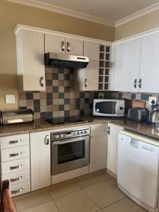 a kitchen with a stove and a microwave at DunPuttin - Pinnacle Point Golf Estate in Mossel Bay
