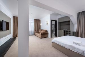 Un dormitorio blanco con una cama y un sofá. en Infinity Villa, en Predeal
