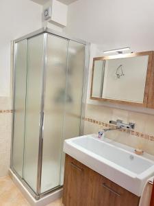 un bagno con doccia in vetro e lavandino di La scelta giusta a Custonaci
