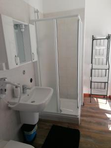 biała łazienka z prysznicem i umywalką w obiekcie BGY Airport Guesthouse w mieście Orio al Serio