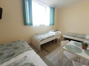 um quarto com duas camas e uma mesa e uma janela em BOSiR Białogard em Bialogard