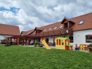 een huis met een tuin met een glijbaan en een speeltuin bij Penzion U Farmáře in Chotoviny