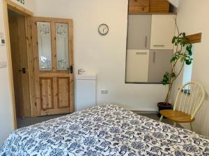 a bedroom with a bed with a blue and white blanket at Rosehip Barn in Launceston