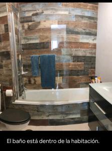 uma casa de banho com uma banheira, um WC e um lavatório. em Habitación suite con baño a pies del río Guadalquivir em Coria del Río