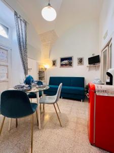a living room with a blue couch and a table and chairs at Casa Agrumeto 28 in Ostuni