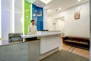a man standing at a counter in a room at Myspace Express Balaji Residency in Bangalore