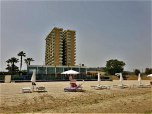 una persona sentada en una playa con sillas y sombrillas en Interno 132, en Porto San Giorgio