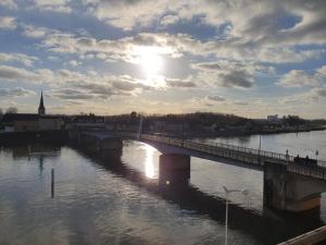 most nad rzeką ze słońcem na niebie w obiekcie La Marion w mieście Saint-Jean-de-Losne