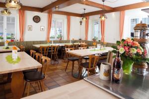 a restaurant with tables and chairs and flowers at Bei Storaths in Oberstreu