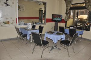 a room with two tables and chairs and a television at HOTEL DE LA VALLEE NEW in Yaoundé