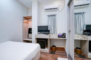 a bedroom with a bed and a desk and a tv at Myspace Express Balaji Residency in Bangalore