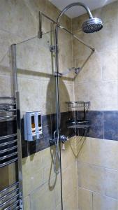um chuveiro com uma porta de vidro na casa de banho em Bracadale House em Port na Long