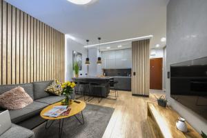salon z kanapą i stołem w obiekcie Kazou Residence Arkadia w Warszawie